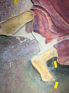 Afbeelding van het restauratieproces van een geglazuurd tegelpaneel.